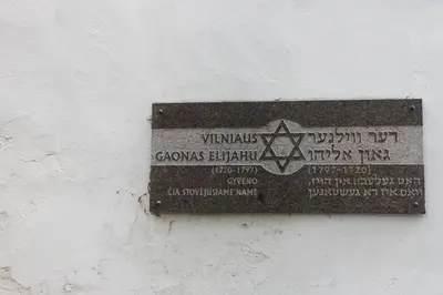 a sign on the side of a white wall at Cottage in old town in Vilnius