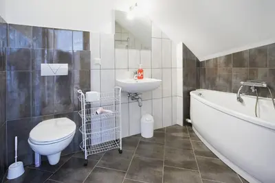 a bathroom with a toilet and a sink and a bath tub at Cottage in old town in Vilnius