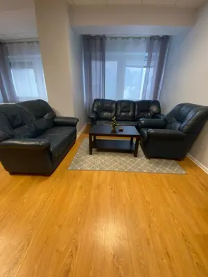 a living room with two leather couches and a coffee table at Perlos Apartamentai 3 in Birštonas