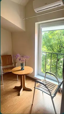 a table and a chair in a room with a window at Centro apartamentai in Birštonas