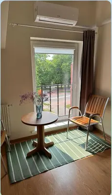 a room with a table and a chair and a window at Centro apartamentai in Birštonas
