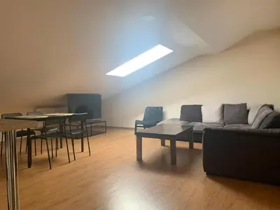 a living room with a couch and a table and chairs at Perlos Apartamentai 14 in Birštonas