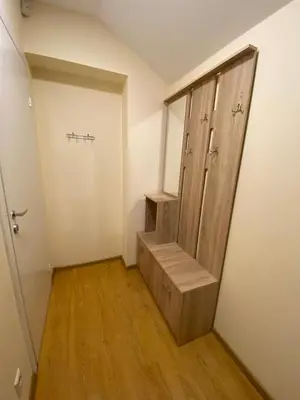 an empty room with a wooden door and stairs at Perlos Apartamentai 14 in Birštonas