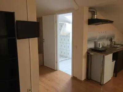 a kitchen with a door leading into a kitchen with a counter at Perlos Apartamentai 14 in Birštonas