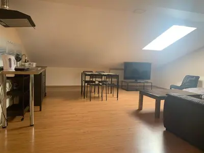 a living room with tables and chairs and a tv at Perlos Apartamentai 14 in Birštonas