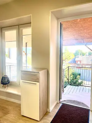 a kitchen with a refrigerator next to a sliding glass door at Kaunas Stay Apartment in Kaunas