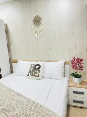 a bedroom with a bed with white sheets and a chandelier at Kaunas Stay Apartment in Kaunas
