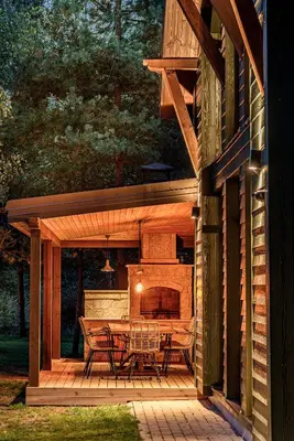 a patio with a table and chairs and a fireplace at Ranča in Molėtai