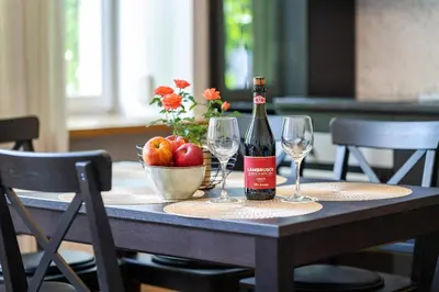 a bottle of wine and two glasses on a table at Premium City Center Lukiskiu Apartment in Vilnius
