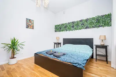 a bedroom with a bed and a plant in it at Premium City Center Lukiskiu Apartment in Vilnius