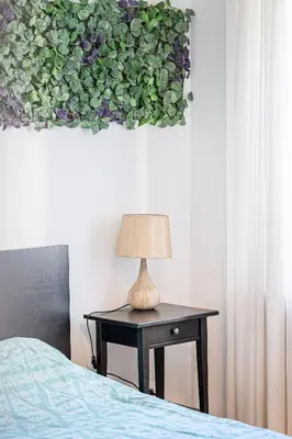 a lamp sitting on a table next to a bed at Premium City Center Lukiskiu Apartment in Vilnius