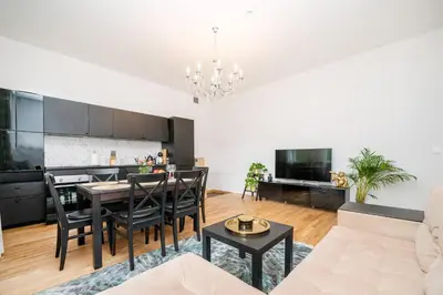 a kitchen and living room with a table and chairs at Premium City Center Lukiskiu Apartment in Vilnius