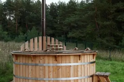 a wooden barrel with two bears sitting on top of it at Liūto kalnas in Trakai