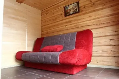 a red couch in a room with wooden walls at Liūto kalnas in Trakai