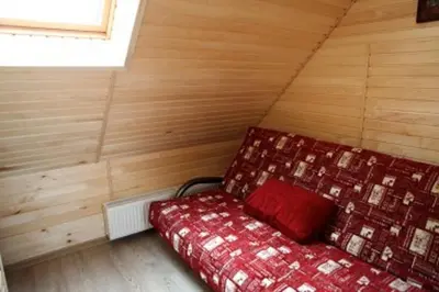a bedroom with a bed in a room with wooden walls at Liūto kalnas in Trakai