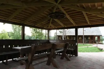 a pavilion with benches and a table and a roof at Liūto kalnas in Trakai