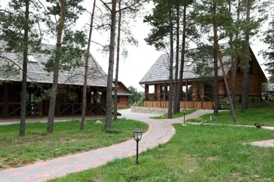 a log cabin with a path leading to a building at Liūto kalnas in Trakai