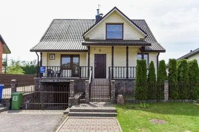 a yellow house with a gate and a fence at Birutes Houses in Druskininkai