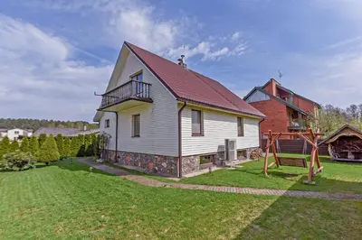 a large white house with a red roof at Birutes Houses in Druskininkai