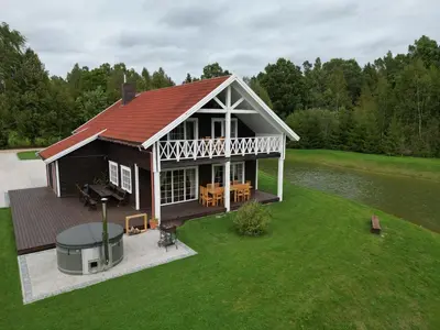 an overhead view of a house with a deck and a lake at Homestead Miško Vingis