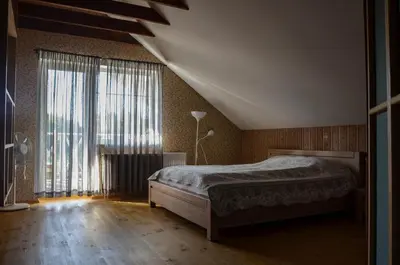 a bedroom with a bed and a large window at Homestead Miško Vingis