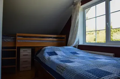 a bedroom with a bed and a desk and a window at Homestead Miško Vingis