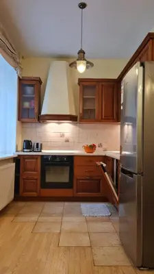 a kitchen with wooden cabinets and a stainless steel refrigerator at Rehouse, Antokolskio 13 in Vilnius