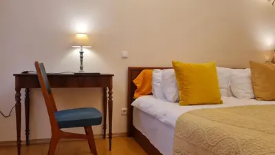 a bedroom with a bed and a desk and a chair at Rehouse, Antokolskio 13 in Vilnius