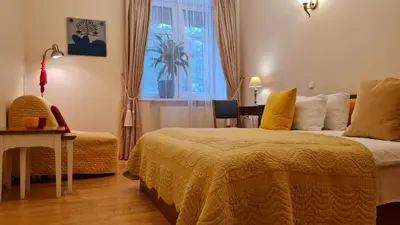 a bedroom with a bed and a table and a window at Rehouse, Antokolskio 13 in Vilnius
