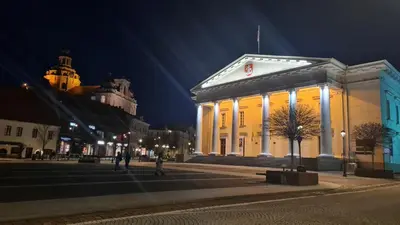 a lit up building in a city at night at Rehouse, Antokolskio 13 in Vilnius