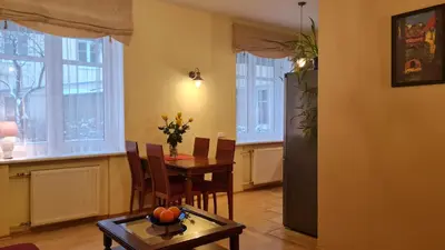 a dining room with a table and chairs and windows at Rehouse, Antokolskio 13 in Vilnius