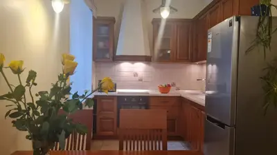 a kitchen with wooden cabinets and a refrigerator at Rehouse, Antokolskio 13 in Vilnius