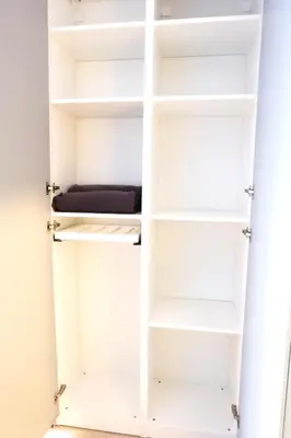 a closet with white shelves in a room at Jaukus Koko butas 1 aukšte in Kaunas