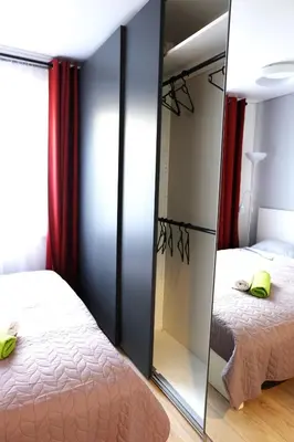 a bedroom with a mirror next to a bed at Jaukus Koko butas 1 aukšte in Kaunas