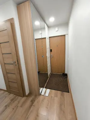 an empty hallway with two doors and a mirror at Tukas Apartment in Marijampolė