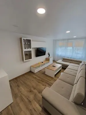 a living room with a couch and a flat screen tv at Tukas Apartment in Marijampolė