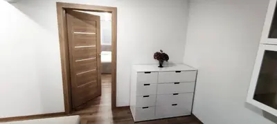 a white dresser in a room with a door at Tukas Apartment in Marijampolė