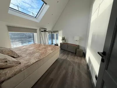 a bedroom with a large bed with a large window at Nemunas River View Apartment in Kaunas