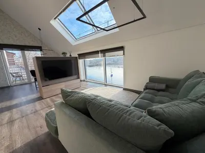 a living room with a couch and a flat screen tv at Nemunas River View Apartment in Kaunas