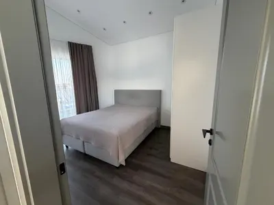 a small bedroom with a bed and a window at Nemunas River View Apartment in Kaunas