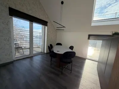 a dining room with a table and chairs and a balcony at Nemunas River View Apartment in Kaunas