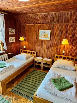 two beds in a room with wooden walls at Maple House - Sodyba Tarp Klevų in Utena