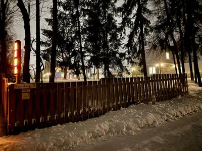 a fence covered in snow in front of a house at Maple House - Sodyba Tarp Klevų in Utena