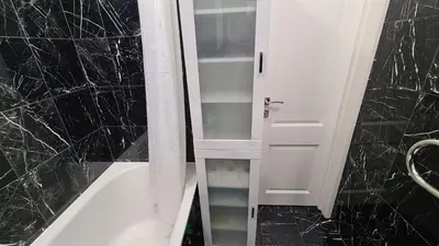 a white cabinet in a bathroom with black marble walls at near the old town in Kaunas