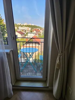 a room with a balcony with a table and a view at near the old town in Kaunas