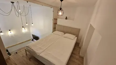 a small bedroom with a bed and a chandelier at Zema5 Old Town Loft in Vilnius