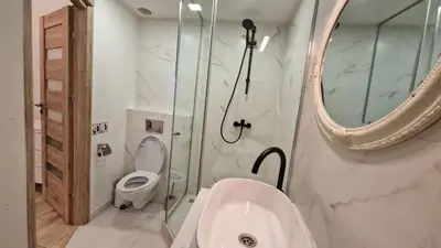 a bathroom with a toilet and a sink and a mirror at Zema5 Old Town Loft in Vilnius
