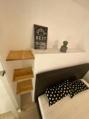 a room with a couch and a shelf with a best to come sign at Zema5 Old Town Loft in Vilnius