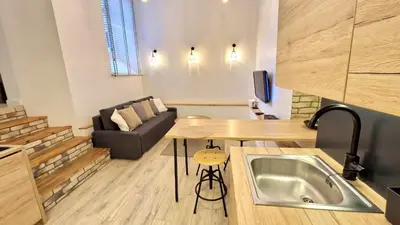 a kitchen and living room with a table and a couch at Zema5 Old Town Loft in Vilnius