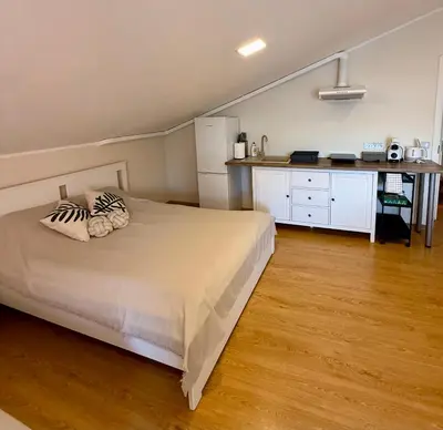 a bedroom with a white bed and a counter at Perlos Apartamentai 12 in Birštonas
